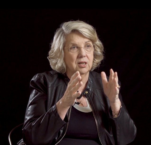 Marsha Linehan with her hands raised mid-explanation.
